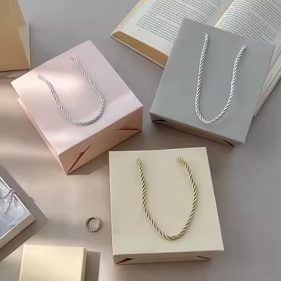 Sacchetto di carta Kraft per lo shopping di lusso economico all'ingrosso della fabbrica OEM con logo personalizzato